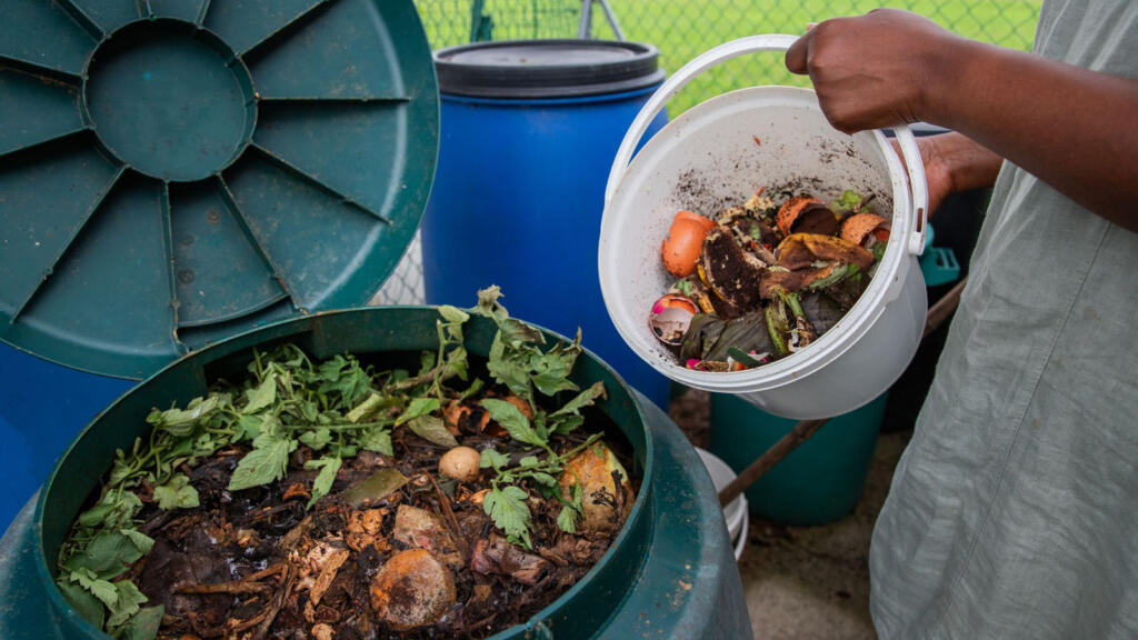 Person emptying a bucket of food scraps into a compost bin