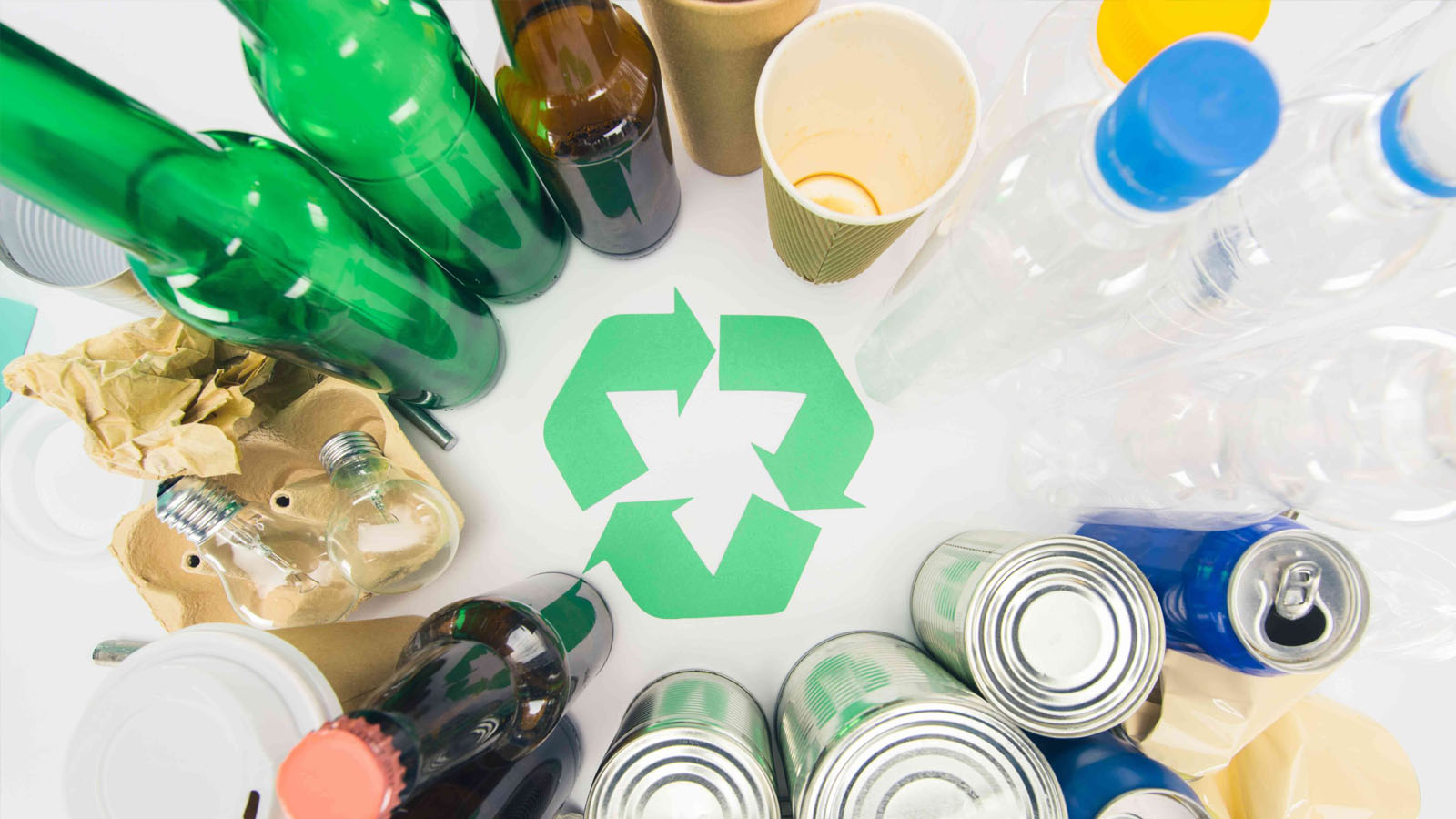 Top view of sorted trash and recyclables with a recycling symbol