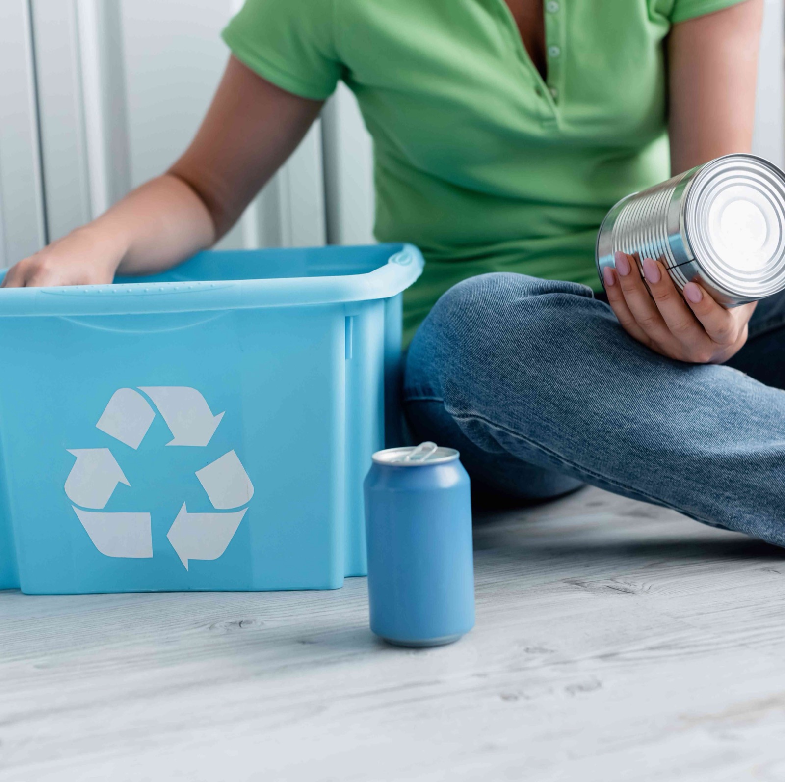 Person sorting a tin can into a recycling box